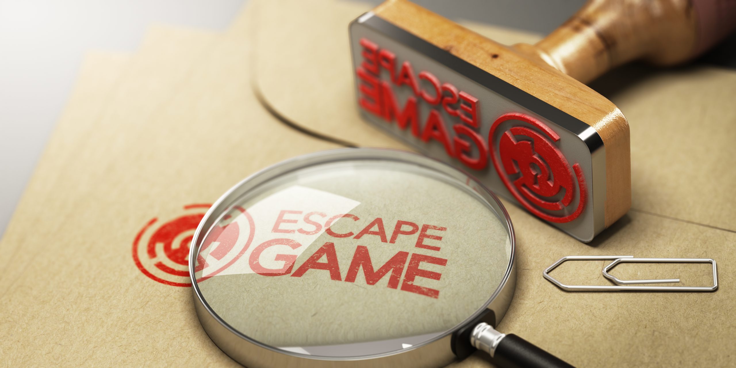 Timbre rouge avec l’inscription « Escape Game » sur une enveloppe en kraft, accompagné d’une loupe grossissante, d’un trombone et d’un tampon en bois.